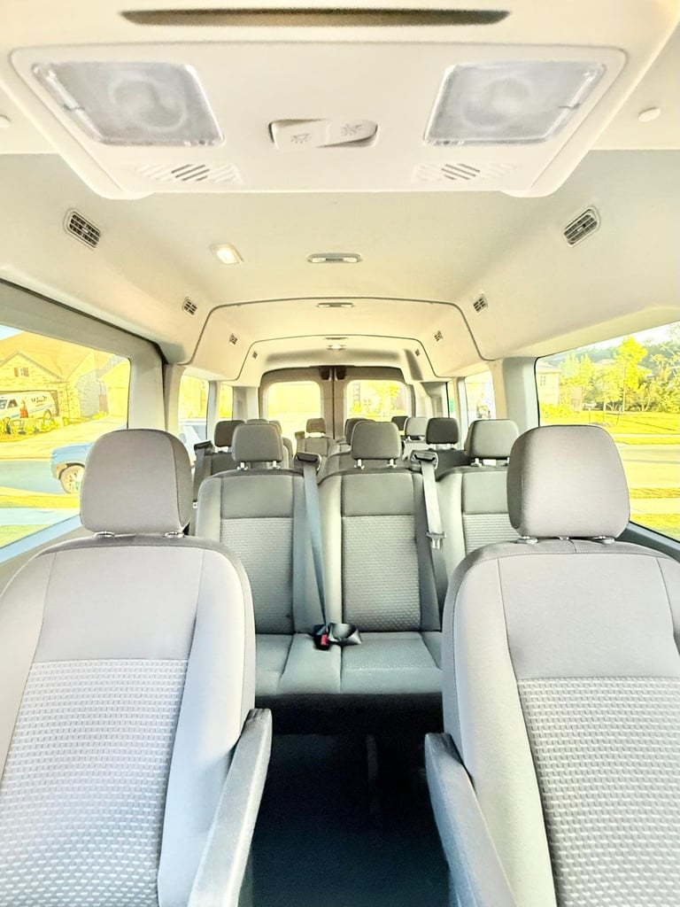Interior of a passenger van showing multiple rows of gray fabric seats